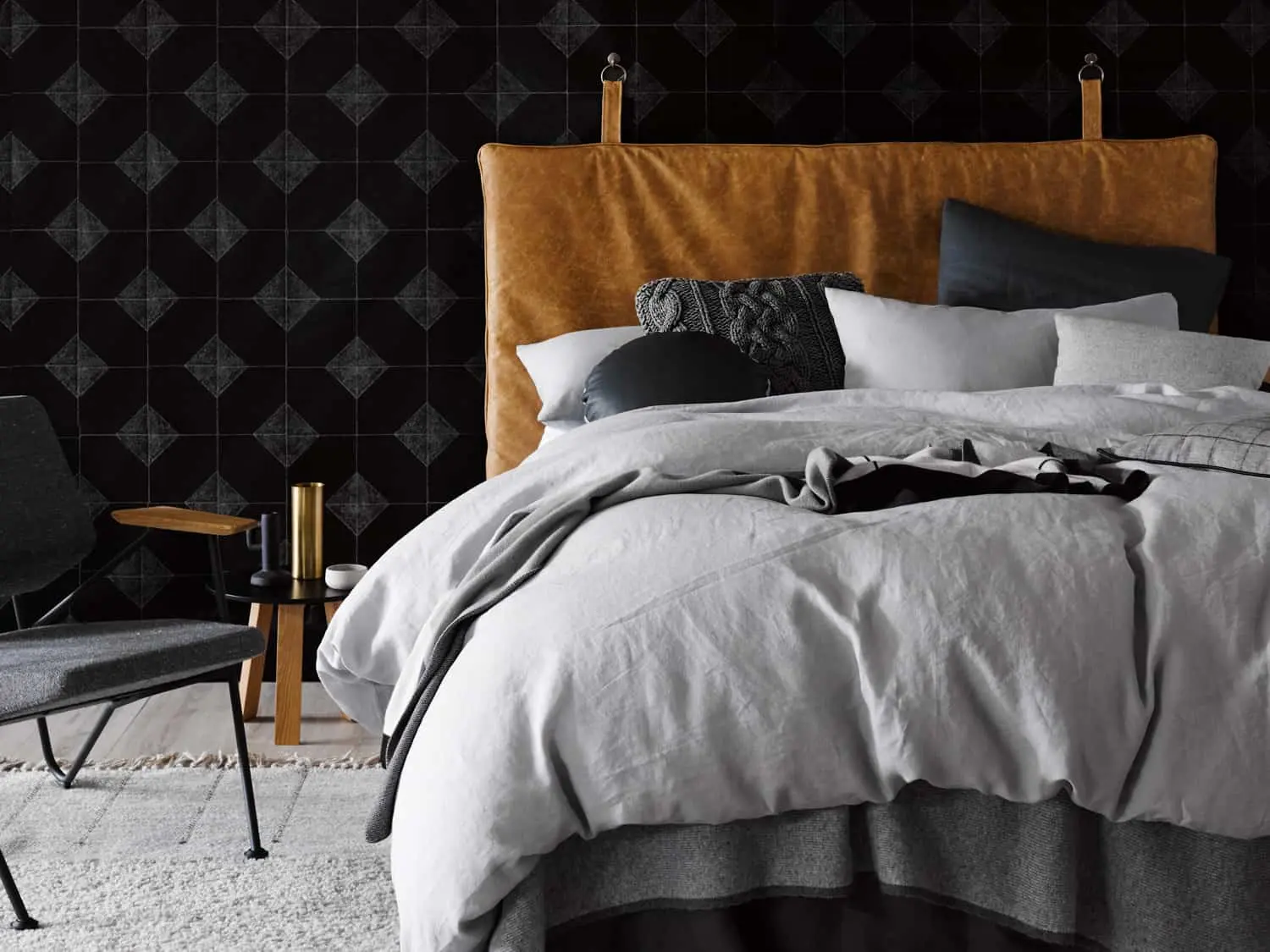 Cozy small bedroom with textured dark headboard and layered bedding.