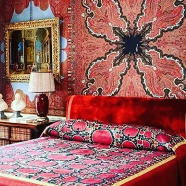 Bohemian red bedroom with mixed patterns.