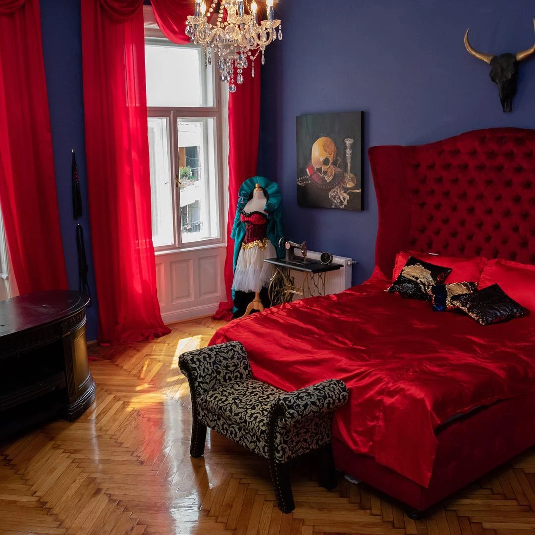 Red and blue bedroom with velvet bed.