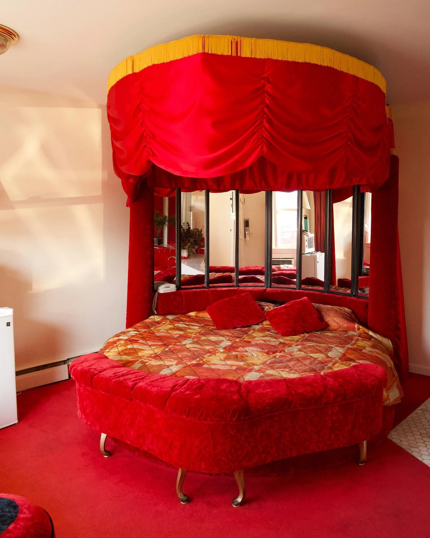Dramatic red bedroom with round velvet bed.