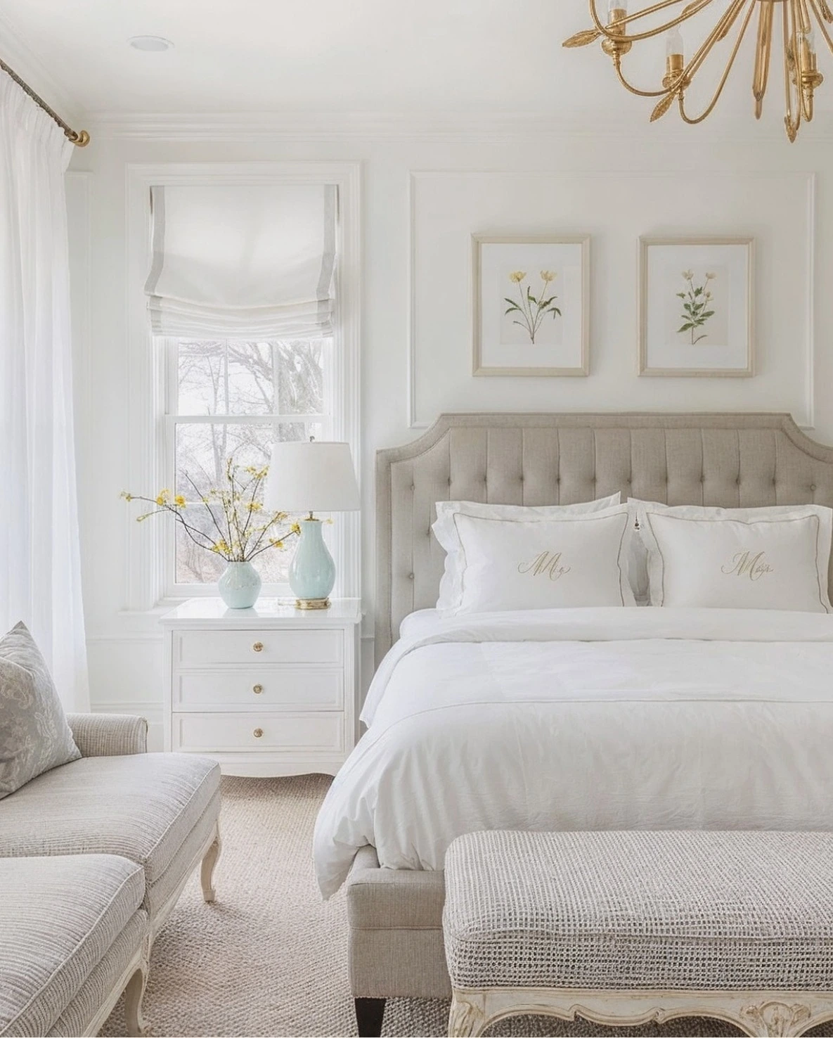 Elegant white and gray bedroom with a tufted headboard and a fancy chandelier.