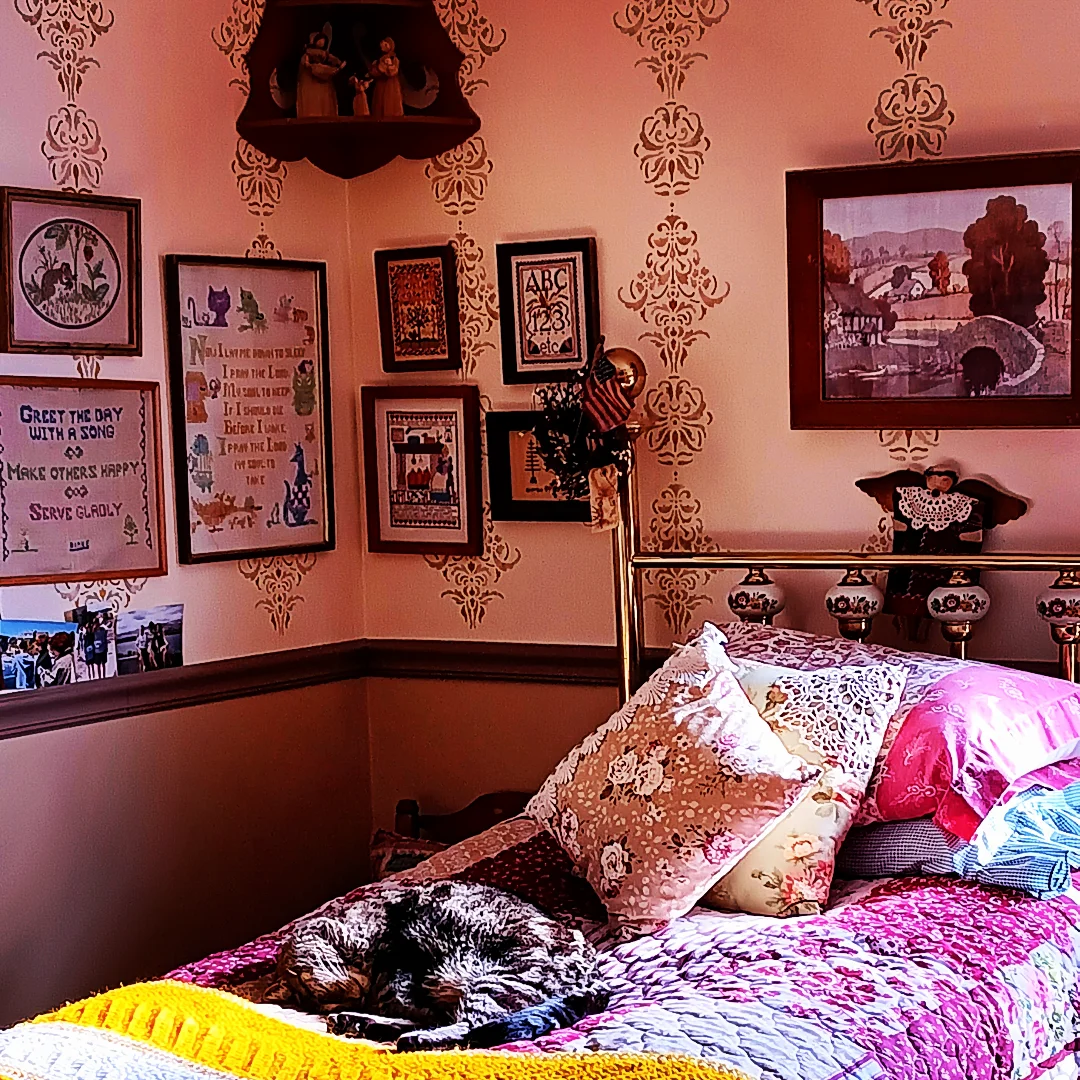 Cozy bedroom with stenciled walls and personal touches.