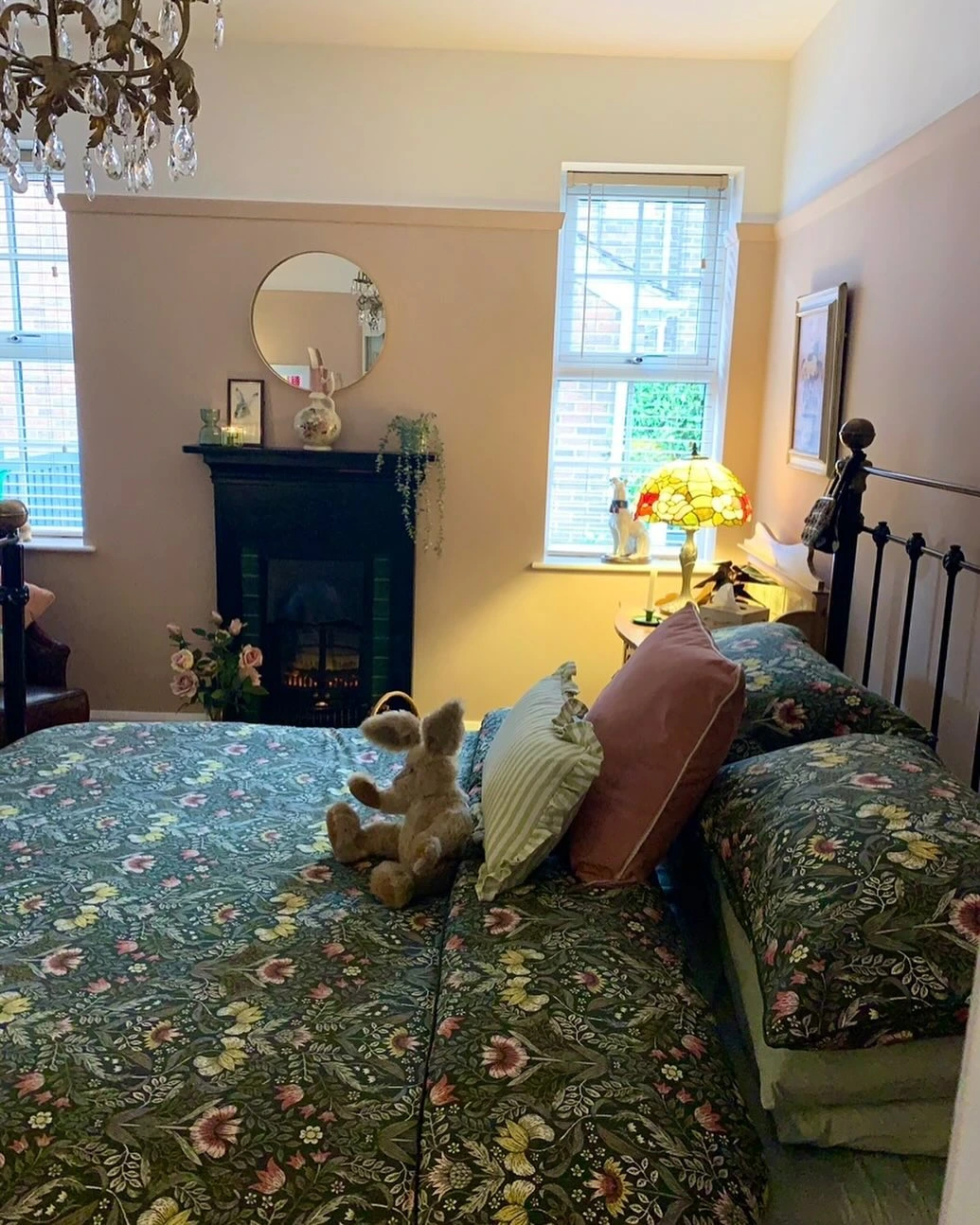 Floral bedding and a fireplace in a cozy bedroom.  