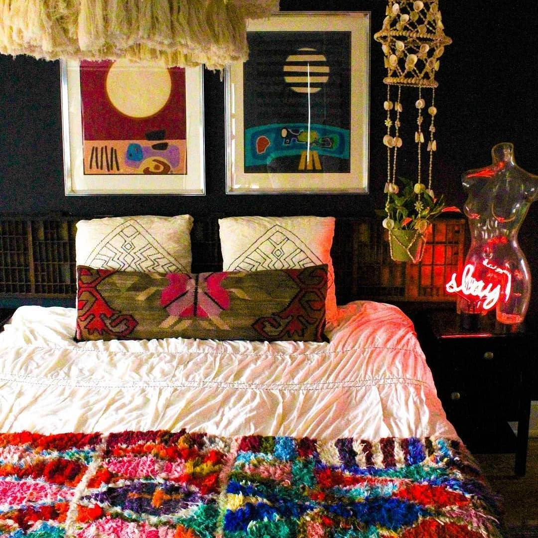 Colorful textured blanket on a bed with abstract art.  