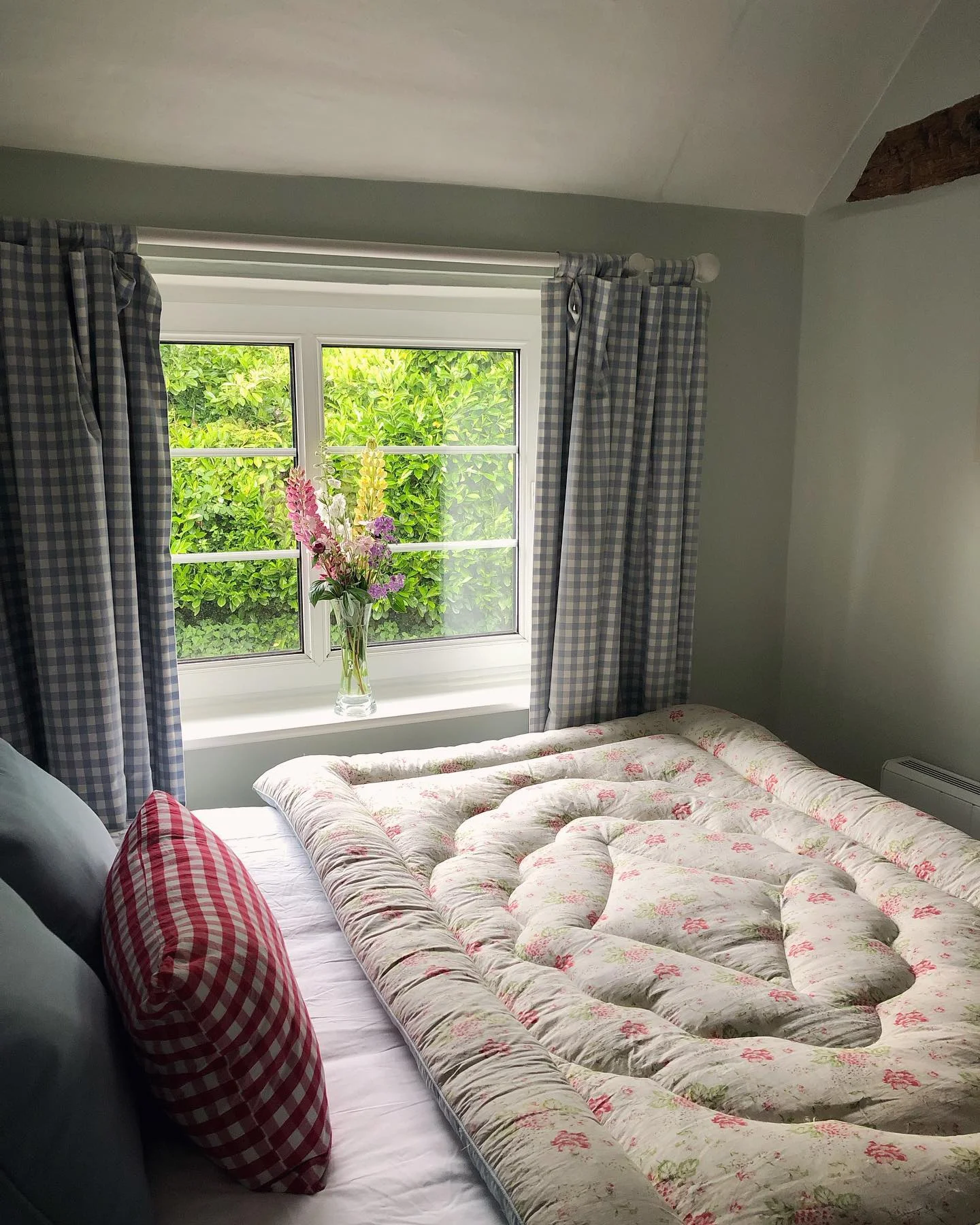 Bedroom with floor mattress and gingham curtains