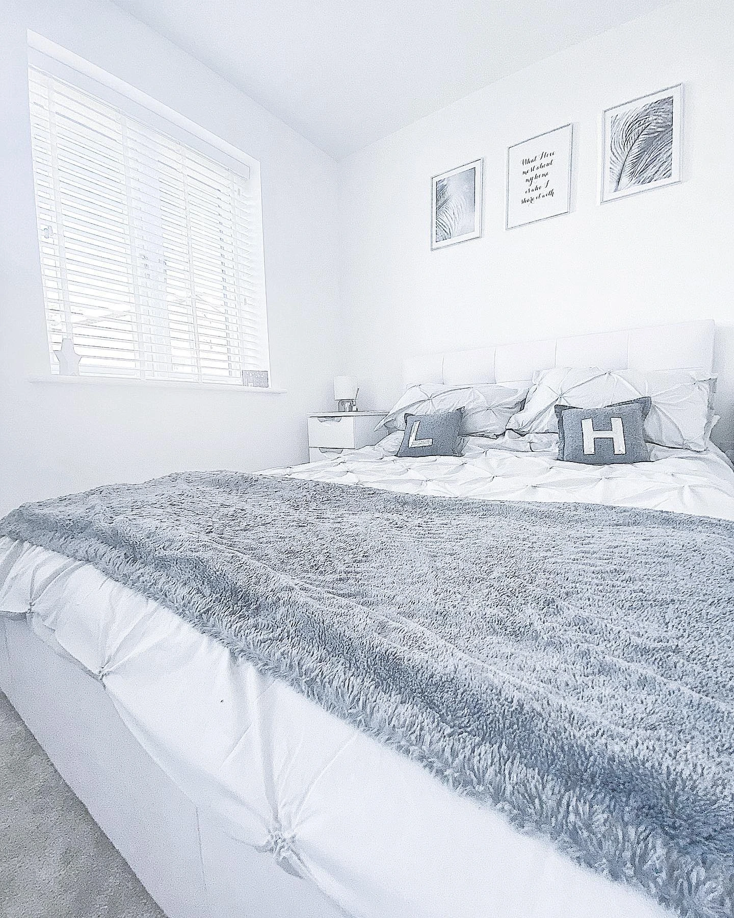 Clean white bedroom with a soft, fuzzy gray blanket.