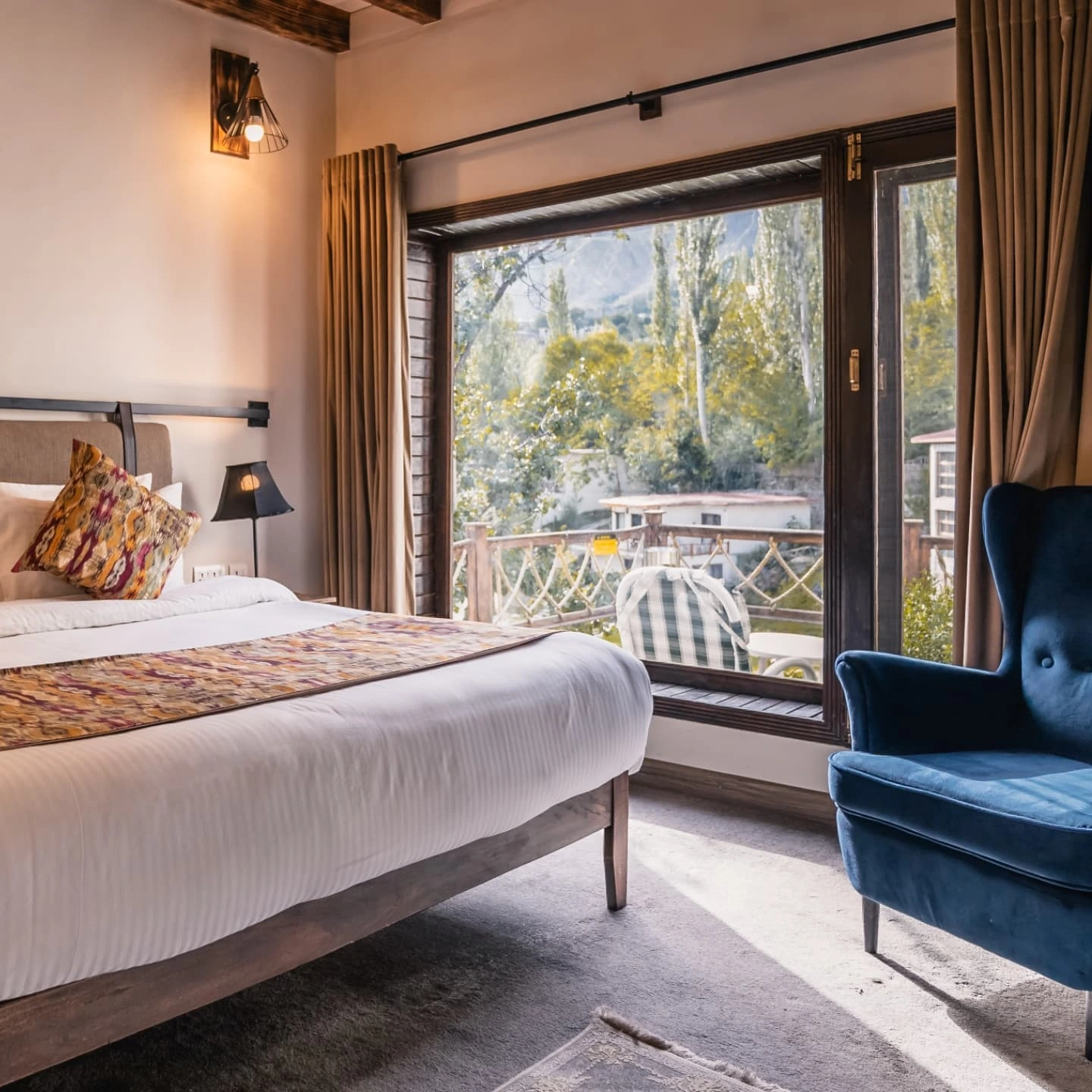 Modern bedroom with a large window and a blue armchair.