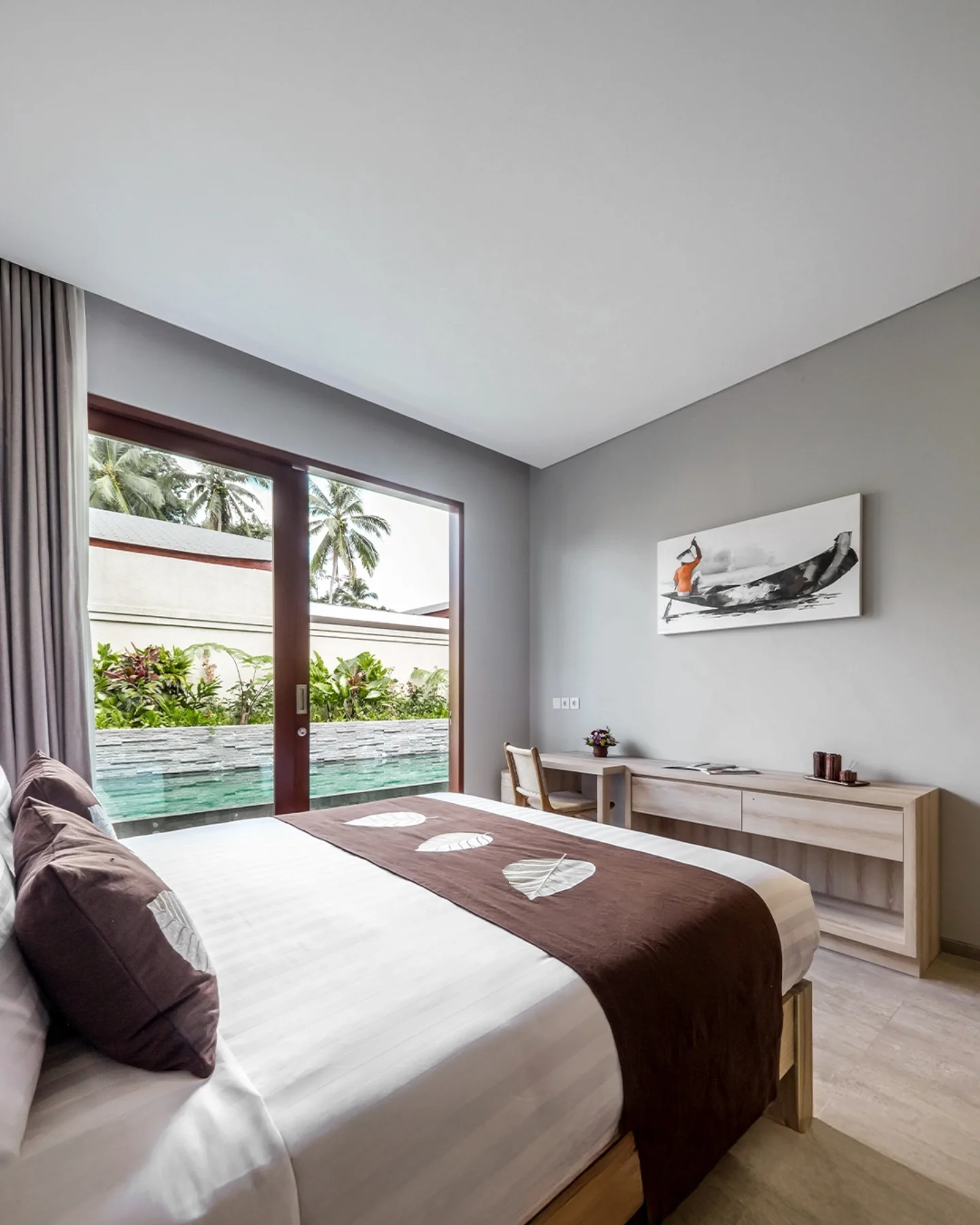 Minimalist bedroom with a view of a swimming pool.