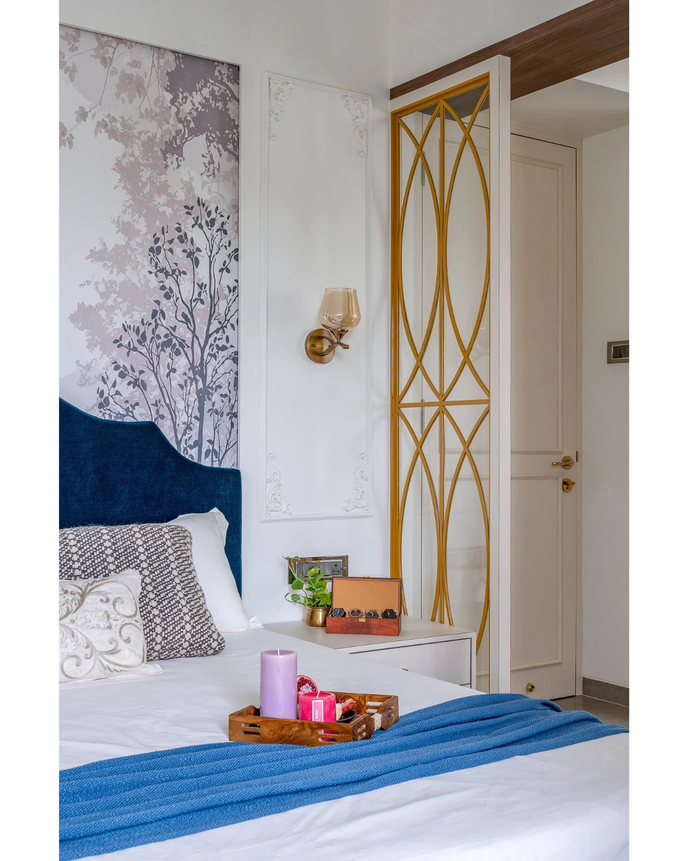 Bedroom with elegant gold room divider and soft wall mural.