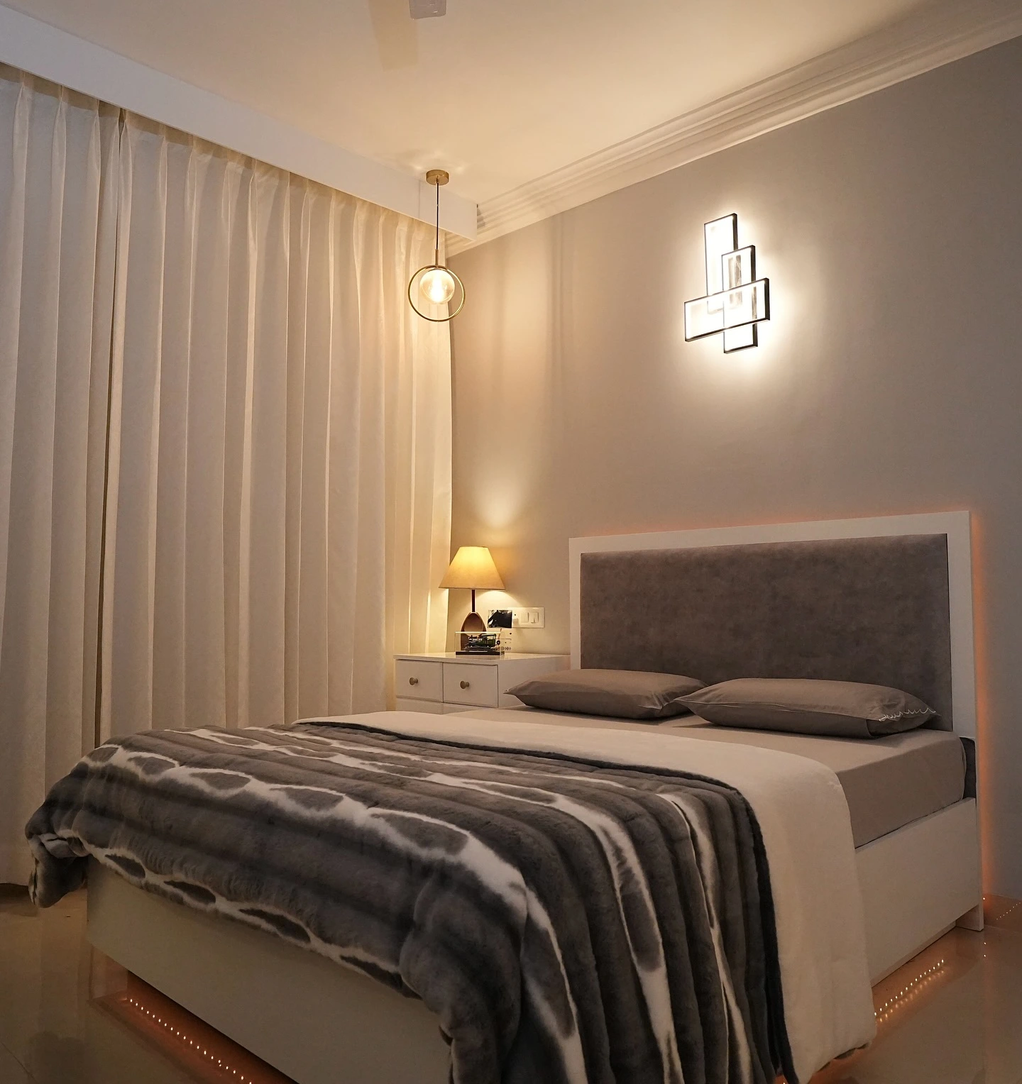 Modern small bedroom with under-bed lighting.