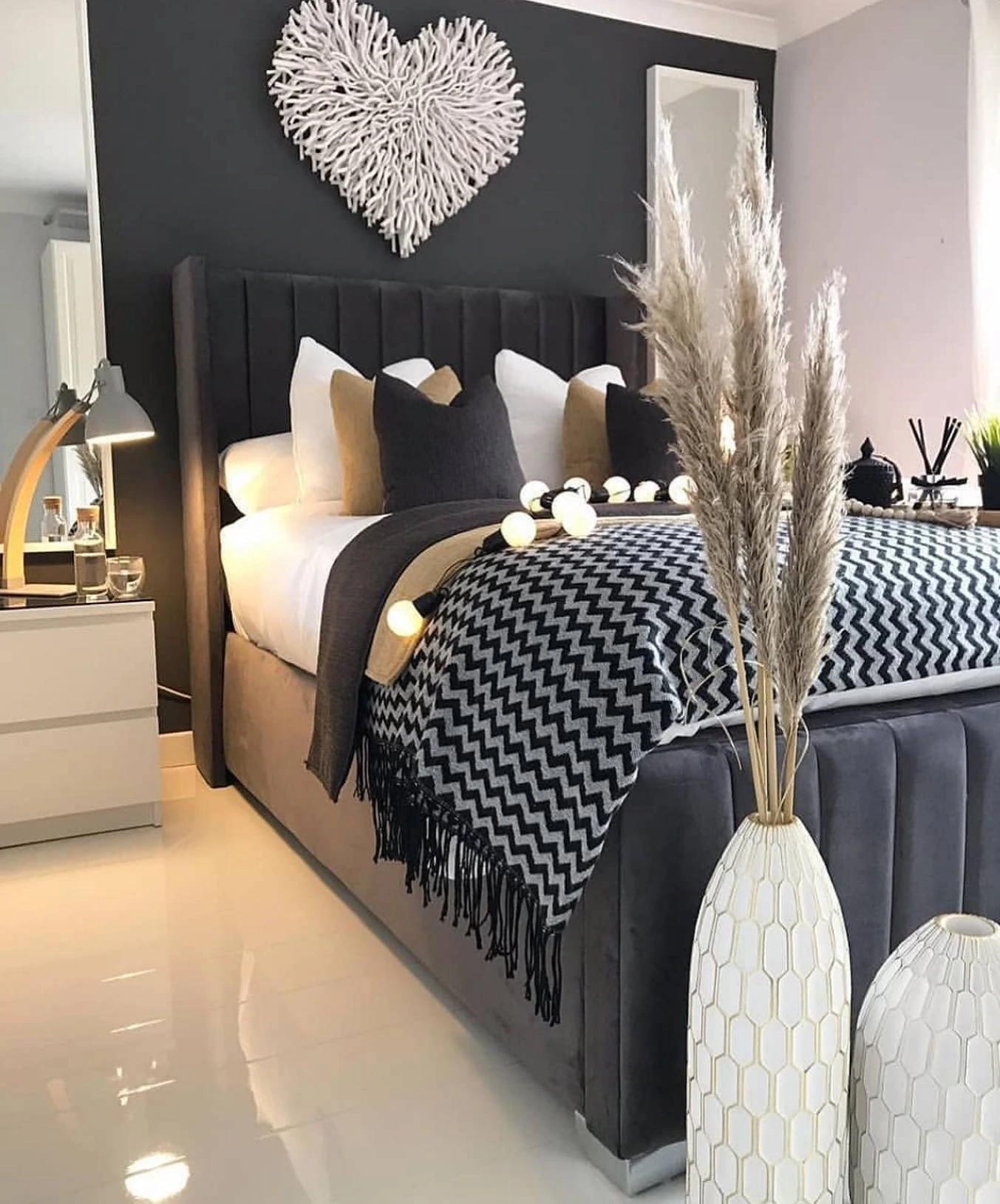 Bed with a dark, plush headboard.  