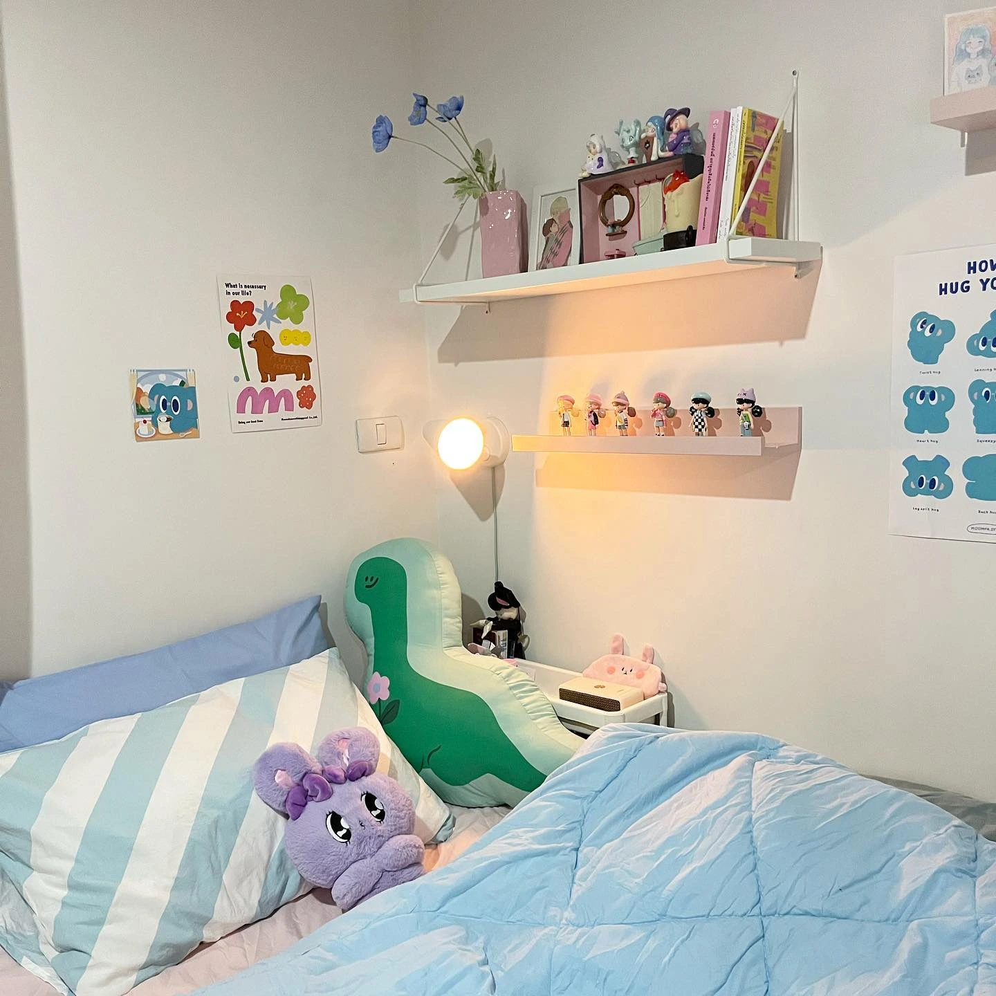 Bed with a wall lamp and a framed poster.  