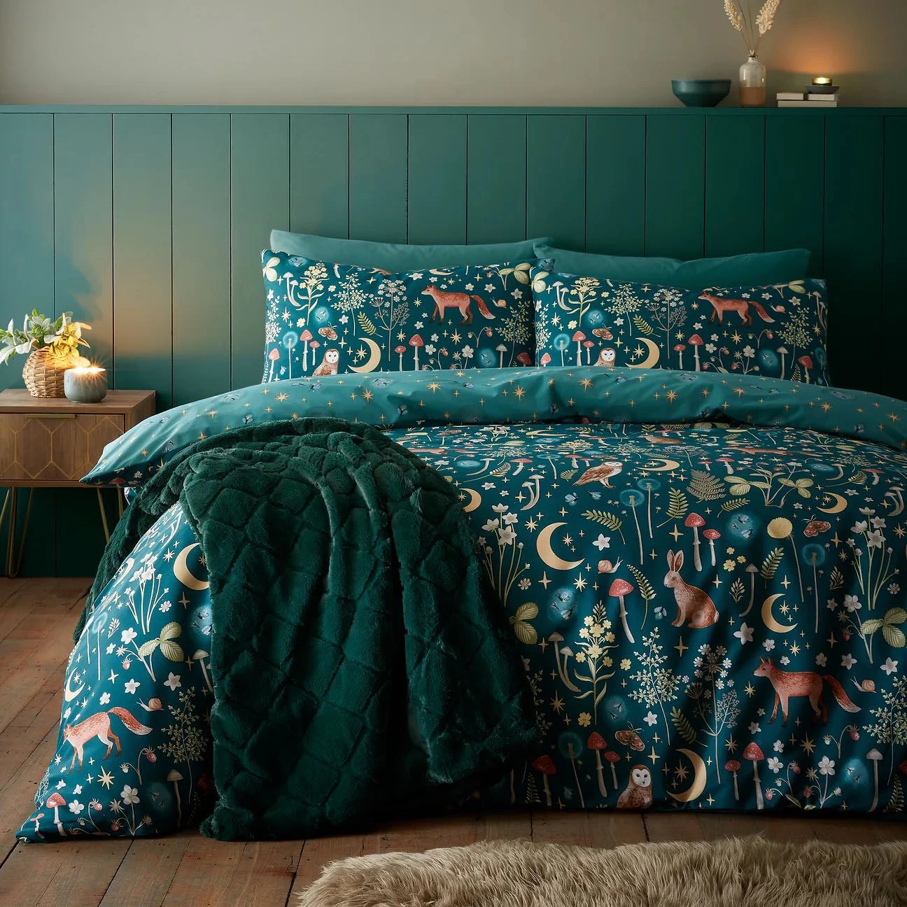 Bed with a whimsical woodland comforter.  